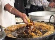 آشپزی که غذای در حال پخت را با دستش بهم هم میزند +عکس